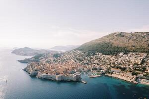 antico porta di dubrovnik con castello muri su il riva del mare a il piede di il montagne. Croazia. fuco foto