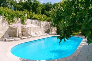 nuoto piscina tra verde alberi nel il cortile foto