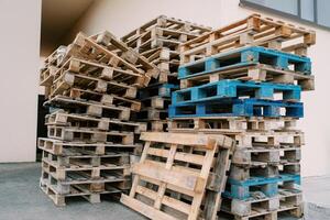 di legno pallet impilati contro il parete di un' edificio foto