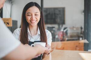 amichevole barista servendo caffè con un' caldo Sorridi per un' cliente nel un' accogliente, invitante bar atmosfera. foto