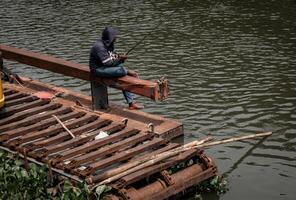 un' persona su un' macchina fatto di galleggiante ferro è pesca nel il lago foto
