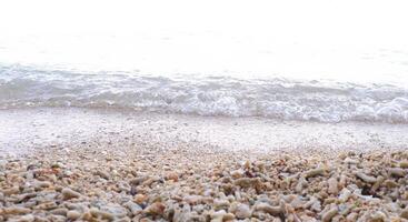 spiaggia sabbia e mare onda su bianca sfondo, morbido messa a fuoco. foto