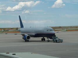 boston, mamma, 2008 - piccolo Jet seduta solo nel aeroporto con blu cielo bianca nuvole foto