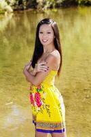 sorridente asiatico americano donna all'aperto acqua sfondo foto