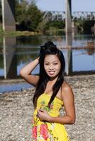 asiatico americano donna giallo vestito fiume sorridente foto