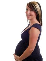 sorridente incinta donna Tenere pancia nel vestito foto