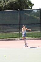 giovane ispanico adolescente ragazza oscillante tennis racchetta foto