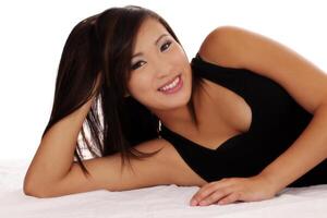 sorridente asiatico americano adolescente ragazza reclinabile su lato foto