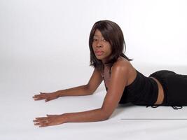 africano americano donna reclinabile su stomaco foto