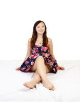 giovane Cinese donna seduta floreale vestito sorridente foto