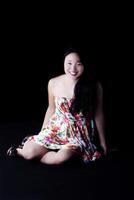 sorridente attraente giapponese americano donna seduta nel vestito foto