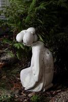 cemento statua di giapponese donna seduta nel giardino foto