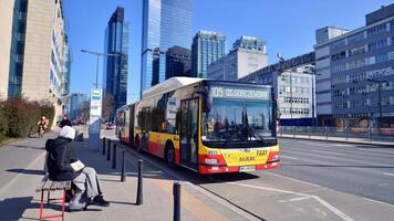 varsavia, Polonia. 7 marzo 2024. pubblico mezzi di trasporto autobus nel il città centro nel il mattina contro un' sfondo di moderno edifici. foto