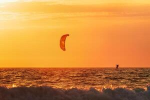 kiteboarding kitesurf kiteboarder kitesurfer aquiloni silhouette nel il oceano su tramonto foto