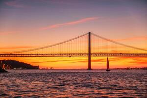 Visualizza di 25 de abril ponte al di sopra di tagus fiume su tramonto. Lisbona, Portogallo foto