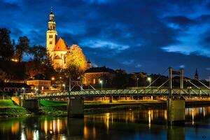 leprosenhauskirche Chiesa e Mullner steg ponte illuminato a notte. salisburgo, Austria foto