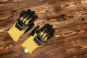 giallo guanti su di legno pavimento. un' paio di luminosa giallo opera guanti con migliorata protezione contro tagli e dossi. foto