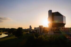 superiore Visualizza di il nazionale biblioteca e un' nuovo Quartiere con un' parco nel minsk-il capitale di il repubblica di bielorussia a tramonto, un' pubblico edificio foto