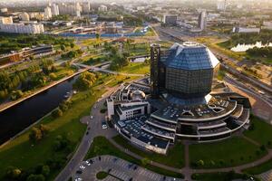 superiore Visualizza di il nazionale biblioteca e un' nuovo Quartiere con un' parco nel minsk-il capitale di il repubblica di bielorussia a tramonto, un' pubblico edificio foto