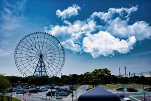 un' Ferris ruota a il parco dietro a il blu cielo largo tiro foto