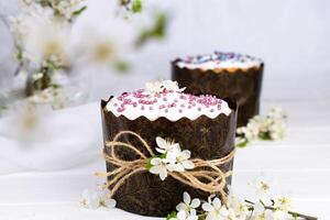 festivo composizione con Pasqua torte decorato con bianca glassatura e un' rametto di ciliegia fiori. cristiano vacanza. avvicinamento. selettivo messa a fuoco. foto