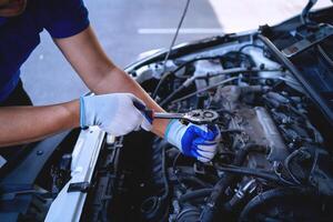 avvicinamento tiro di auto meccanica mani Lavorando su auto motore nel riparazione negozio. auto servizio tecnico opera nel riparazione negozi e Manutenzione Servizi foto