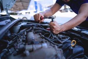 avvicinamento tiro di auto meccanica mani Lavorando su auto motore nel riparazione negozio. auto servizio tecnico opera nel riparazione negozi e Manutenzione Servizi foto