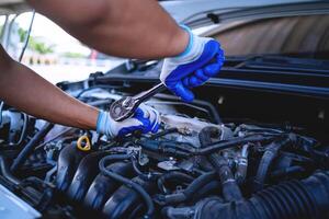 avvicinamento tiro di auto meccanica mani Lavorando su auto motore nel riparazione negozio. auto servizio tecnico opera nel riparazione negozi e Manutenzione Servizi foto