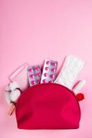 borsa cosmetica rosa e prodotti per l'igiene femminile per le mestruazioni. assorbenti, tamponi, compresse. foto