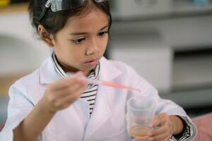 asiatico bambino ragazza apprendimento scienza chimica con test tubo fabbricazione sperimentare a scuola laboratorio. formazione scolastica, scienza, chimica, e figli di concetti. presto sviluppo di bambini. foto