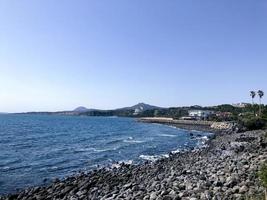 lava solidificata vicino all'acqua del mare nell'isola di jeju. Corea del Sud. foto