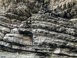 roccia stratificata su un'alta riva del mare ripida foto