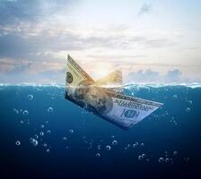 barca fatto di dollaro banconota siamo naufragio nel il oceano foto