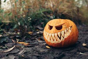 Halloween jack-o-lanterna con antropomorfo sorridente viso su autunno le foglie all'aperto foto