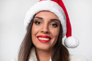 vicino su ritratto bellissimo caucasico donna nel rosso Santa cappello su bianca studio sfondo. Natale e nuovo anno vacanza concetto. foto