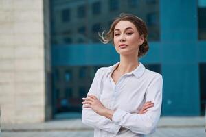 donna d'affari riuscito donna attività commerciale persona in piedi braccia attraversato all'aperto aziendale edificio esterno. pensiv caucasico fiducia professionale attività commerciale donna mezzo età foto