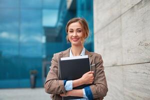 donna d'affari riuscito donna attività commerciale persona in piedi all'aperto aziendale edificio esterno. pensiv caucasico fiducia professionale attività commerciale donna mezzo età foto