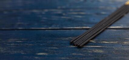 sandalo bastoni su un' nero di legno tavolo. tradizionale asiatico cultura. aromaterapia foto