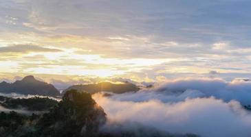 bellissima alba di montagna con luce solare e nebbia sulle montagne del nord della Thailandia foto