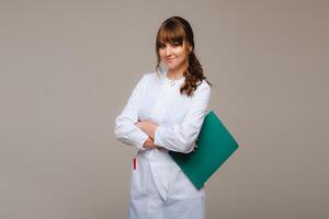 ritratto di un' femmina medico lavoratore nel un' grigio sfondo con un' medico report.girl medico con un' bloc notes foto
