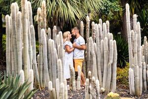 un' amorevole coppia abbraccia contro il fondale di enorme cactus su il isola di tenerife.people nel amore nel il canarino isole.grandi cactus nel tenerife foto