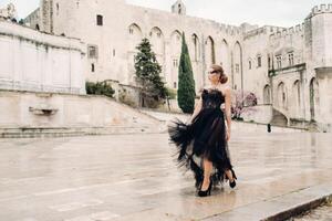 un' elegante sposa nel un' nero nozze vestito pose nel il antico francese città di Avignone. modello nel un' bellissimo nero vestire. foto sparare nel provenza.