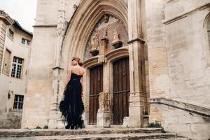 un' elegante sposa nel un' nero nozze vestito pose nel il antico francese città di Avignone. modello nel un' bellissimo nero vestire. foto sparare nel provenza.