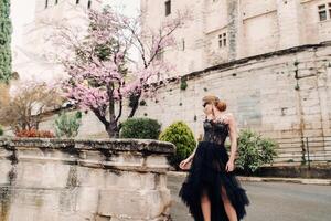 un' elegante sposa nel un' nero nozze vestito pose nel il antico francese città di Avignone. modello nel un' bellissimo nero vestire. foto sparare nel provenza.