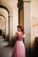 un' giovane bellissimo sposa sta a il centro di il vecchio città di Firenze nel Italia. sposa nel un' bellissimo rosa vestito nel toscana.italia foto