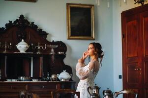 un' sposa nel biancheria intima e un' bianca accappatoio nel il interno di un' villa nel Italia a un' matrimonio.mattina di il sposa nel toscana.boudoir foto sessione a il villa.