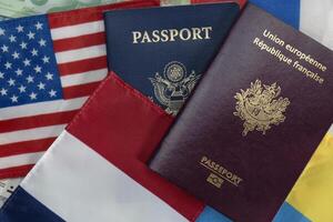 unito stati e Francia passaporti su Euro moneta e francese, americano, russo e Ucraina bandiere foto