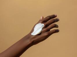 ai generato ritagliata Visualizza di africano americano donna l'applicazione cosmetico crema su mano isolato su beige foto