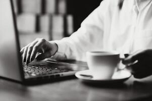 ritagliata tiro Visualizza di giovane donna tastiera su il computer portatile computer con vuoto copia spazio schermo mentre seduta nel bar, bionda femmina alunno Lavorando su netbook dopo sua lezioni nel università, chiarore sole foto