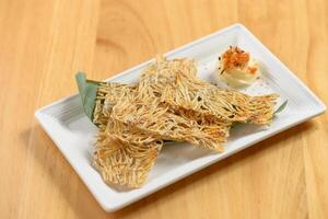 giapponese cibo fritte tatami iwashi nel un' bianca piatto isolato su di legno tavolo superiore Visualizza foto